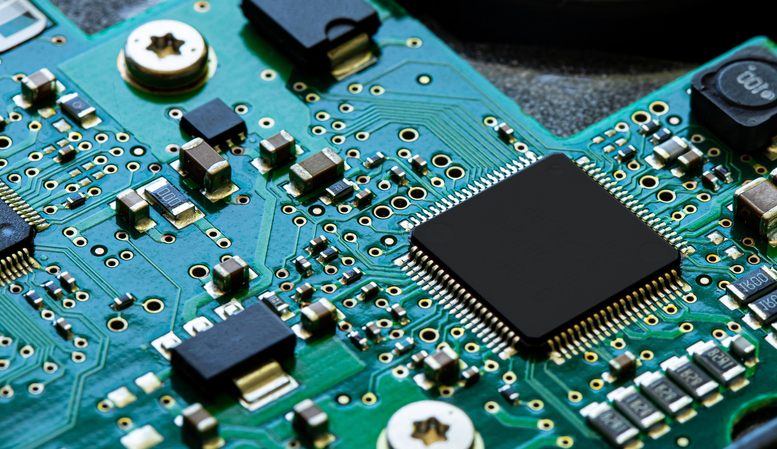 A close-up of an electronic circuit board with soldered connections, illustrating tin's crucial role in soldering for electrical circuits, which influences its supply and demand.