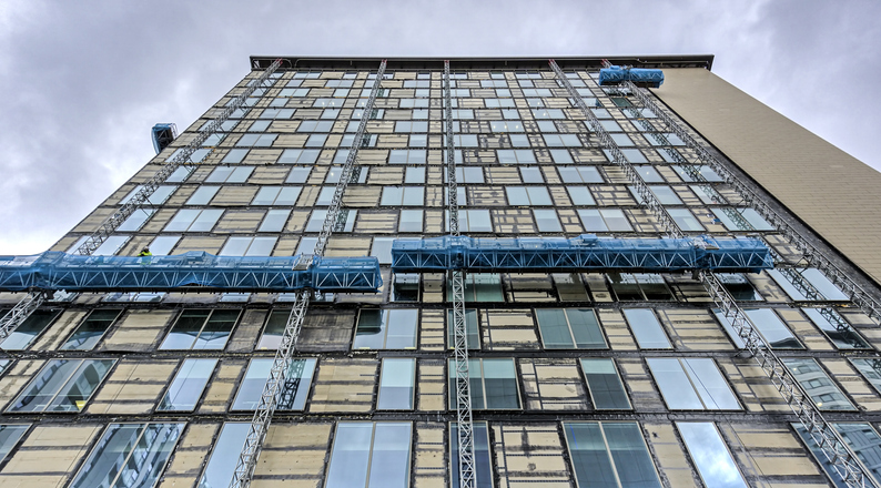 A building under construction, highlighting the widespread use of aluminum in windows, doors, and panels due to its strength, light weight, and corrosion resistance.